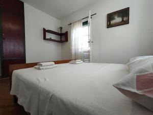 特尔帕尼Apartments by the sea Trpanj, Peljesac - 15995的一张白色的床,上面有两条毛巾
