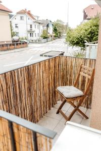 卢布尔雅那White Apartment的木椅,位于带围栏的阳台