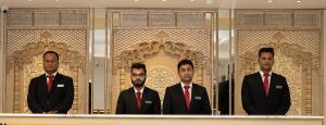 拉杰沙希Royal Raj Hotel的三人穿着西装站在窗前