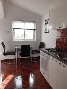 帕格Apartment Pag 16100c的厨房配有桌椅和水槽。