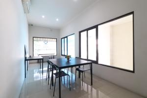 雅加达Uptown Residence Syariah Pondok Pinang的用餐室设有黑色桌椅和窗户。