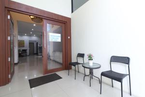 雅加达Uptown Residence Syariah Pondok Pinang的大楼内的房间,配有两把椅子和一张桌子
