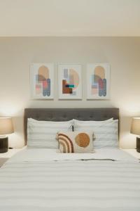 渥太华Modern, Luxurious Apartment near Downtown Ottawa的一间卧室配有一张带两盏灯的大型白色床。