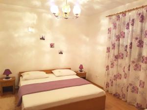 斯拉诺Apartments by the sea Slano, Dubrovnik - 15787的一间卧室配有一张床和一个吊灯