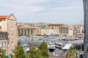 马赛Vue Vieux-Port et Notre Dame, Atypique, Calme, Clim, T2 Chic 48M2,Accès avec code的一座有建筑物的城市里,有船只的港口