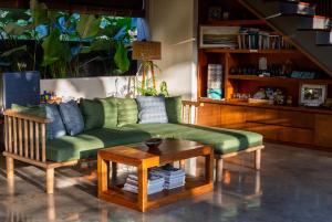 乌鲁瓦图梅拉利滨宁旅馆的客厅配有绿色沙发和桌子