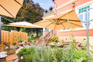 耶弗尔Parkhotel Jever的花园内带桌子和遮阳伞的庭院