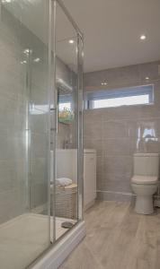 马根波思Hegarty's cottage at Trevarrian Lodge的一间带玻璃淋浴和卫生间的浴室