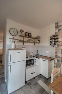 洛兹尼察Drina River Glamping的厨房配有白色家电和墙上的时钟