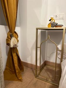 格拉纳达Sueños de la Alhambra的一张金边桌子,床边挂着窗帘
