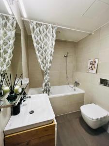 布拉格White Pearl Studio with parking in Holešovice的一间带水槽、浴缸和卫生间的浴室
