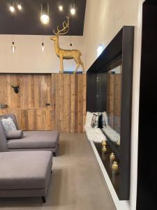 圣迈克尔隆高Das Liftplatzl的客厅配有沙发和墙上的鹿头