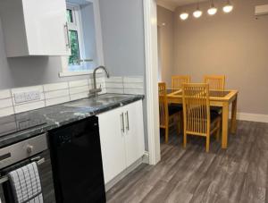 BlaydonBeautiful 2 Bed Apt with Hot Tub in Blaydon Burn的厨房配有水槽和桌椅