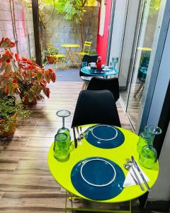 藻德济Moya Résidence by MD的天井上一张带盘子的黄色桌子
