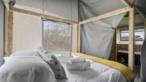 赫特福德Finest Retreats - The Herdwick Safari Tent的一间卧室配有一张天蓬床和窗户