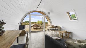 赫特福德Finest Retreats - The Highland Camping Pod的客厅设有拱形窗户和桌子
