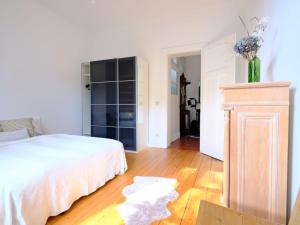 埃森Entspanntes Wohnen in der Nähe des Baldeneysee的卧室配有白色的床,铺有木地板