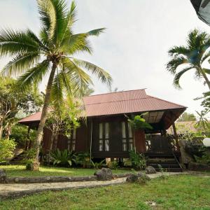 珍拉丁LaVilla By Holiday Villa Cherating的前面有棕榈树的房子