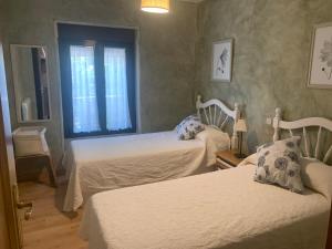 拉·格兰哈·圣·伊尔德Casa del Plantel的一间卧室设有两张床和窗户。