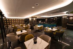 伊斯坦布尔Costera Hotel的一间带桌椅的餐厅和一个游泳池