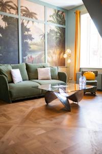 欧塞尔La Villa Ribière的客厅配有绿色沙发和玻璃桌