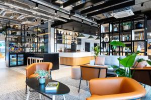 都柏林Staycity Aparthotels Dublin City Centre的一间设有橙色椅子和桌子的餐厅