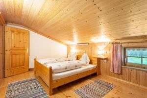 洛弗附近圣马丁Ferienwohnung Jägermeister的木制客房内的一间卧室,配有一张床