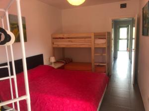 卡拉法特Apartamento Calafat, a 2 minutos a pie de Cala Llobeta的一间卧室配有两张双层床和一张红色的床。
