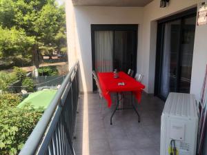 卡拉法特Apartamento Calafat, a 2 minutos a pie de Cala Llobeta的房屋阳台的红色桌子