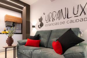 阿尔巴塞特Urbanlux Olimpia Sleep & More的客厅配有绿色沙发和红色枕头