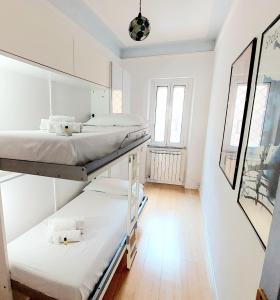 罗马BBHOME Comfort apartment near Colosseum的白色墙壁客房的两张床