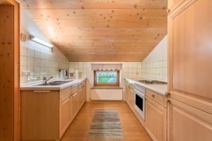 洛弗附近圣马丁Ferienwohnung Spielberg的一间带木制天花板和木地板的厨房