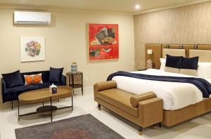 卡拉奇Ambiance Boutique Art Hotel Karachi的一间卧室配有一张床和一张沙发