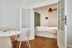 德帕内Appartement La Cabane的卧室配有一张床和一张桌子及椅子