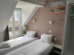 巴黎Hôtel Apollo Opéra的小型客房 - 带2张床和窗户