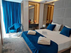 奥林普STEAUA DE MARE - Olimp Resort的一间卧室配有一张带蓝色床单和蓝色椅子的床