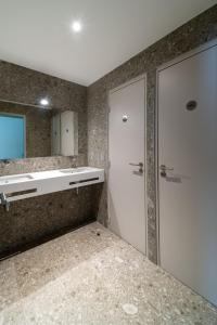 巴黎巴黎阿德维尼亚特旅舍的带淋浴、水槽和门的浴室
