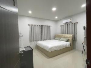 素可泰Phu Thai Resort的一间卧室配有一张床和一台电视