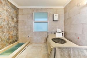 阿巴诺泰尔梅奎希桑纳温泉酒店的带浴缸的浴室和窗户。