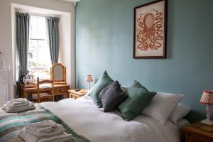 赫尔斯顿Three Tuns的一间卧室配有带绿色和白色枕头的床