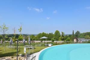 明乔河畔的瓦雷奇奥Agricampeggio Corte Tonolli的公园内一个带椅子和遮阳伞的游泳池