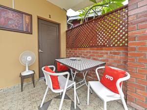 珍南海滩OYO Home 90348 Inspire Rooms的一个带桌椅和砖墙的庭院