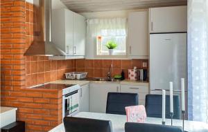 费尔耶斯塔登Lovely Home In Frjestaden With Wifi的厨房配有白色橱柜和桌椅