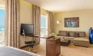 迪拜The Tower Plaza Hotel Dubai的酒店客房配有一张床、一张书桌和一张沙发。