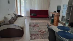 塞克希费黑瓦尔Veronika Apartment的带沙发和红色椅子的客厅