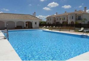 阿尔科斯-德拉弗龙特拉Villa Fairways Golf By Mila Prieto的一座大蓝色游泳池,位于房子前