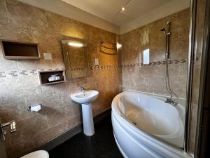 斯基普顿赫利厄特酒店的带浴缸、盥洗盆和卫生间的浴室