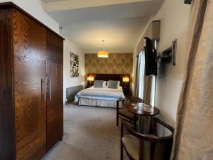 斯基普顿赫利厄特酒店的一间卧室配有一张床、一张桌子和一张书桌