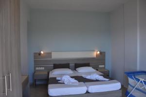 普拉基亚斯塔拉萨之家公寓式酒店的一间卧室配有两张床和白色毛巾。