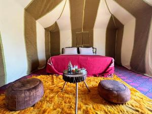 梅尔祖卡Merzouga Camp & Desert Activities的一间卧室配有一张床和两张搁脚凳